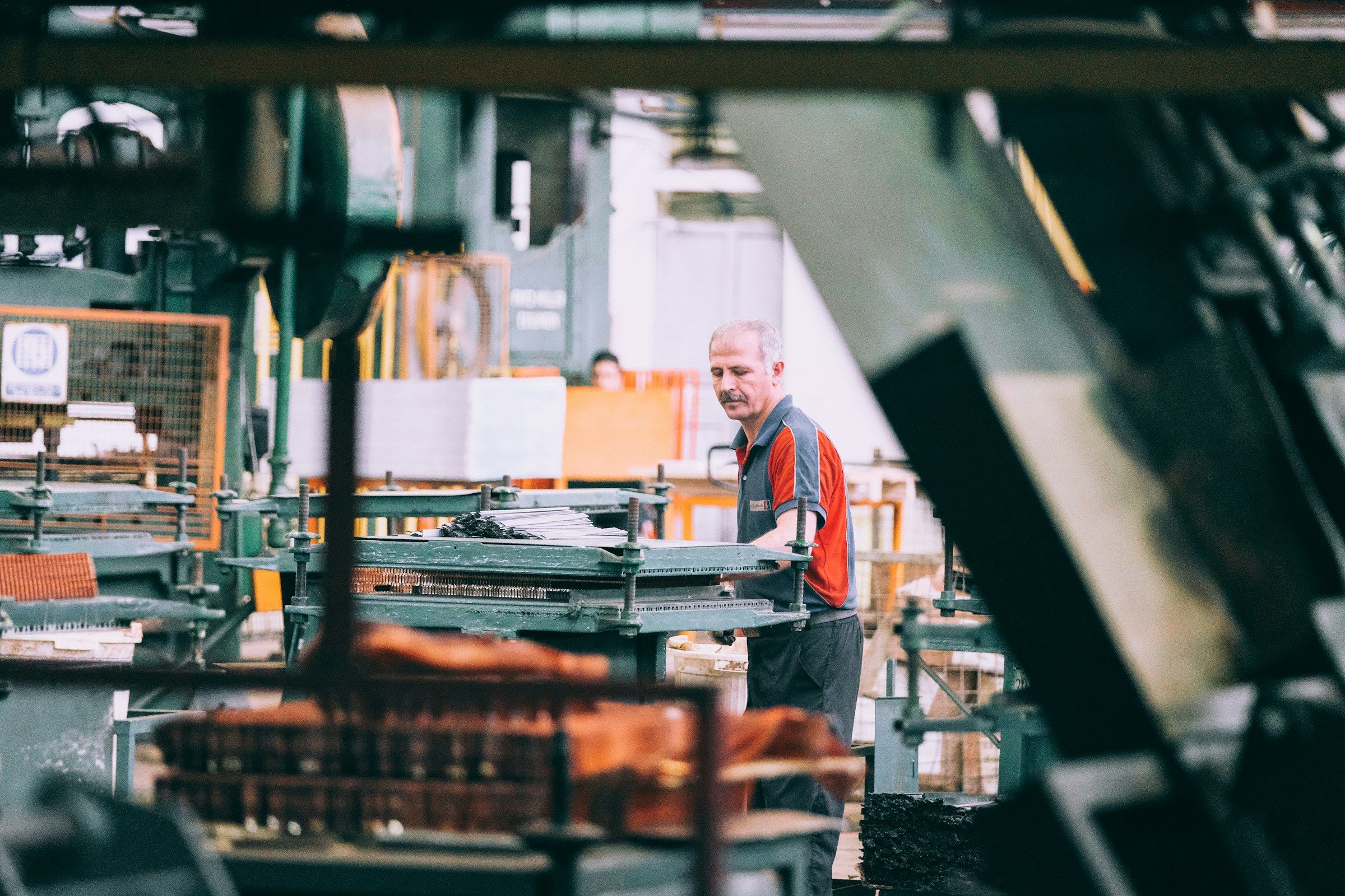An operator adjusts a machine in a production workshop.