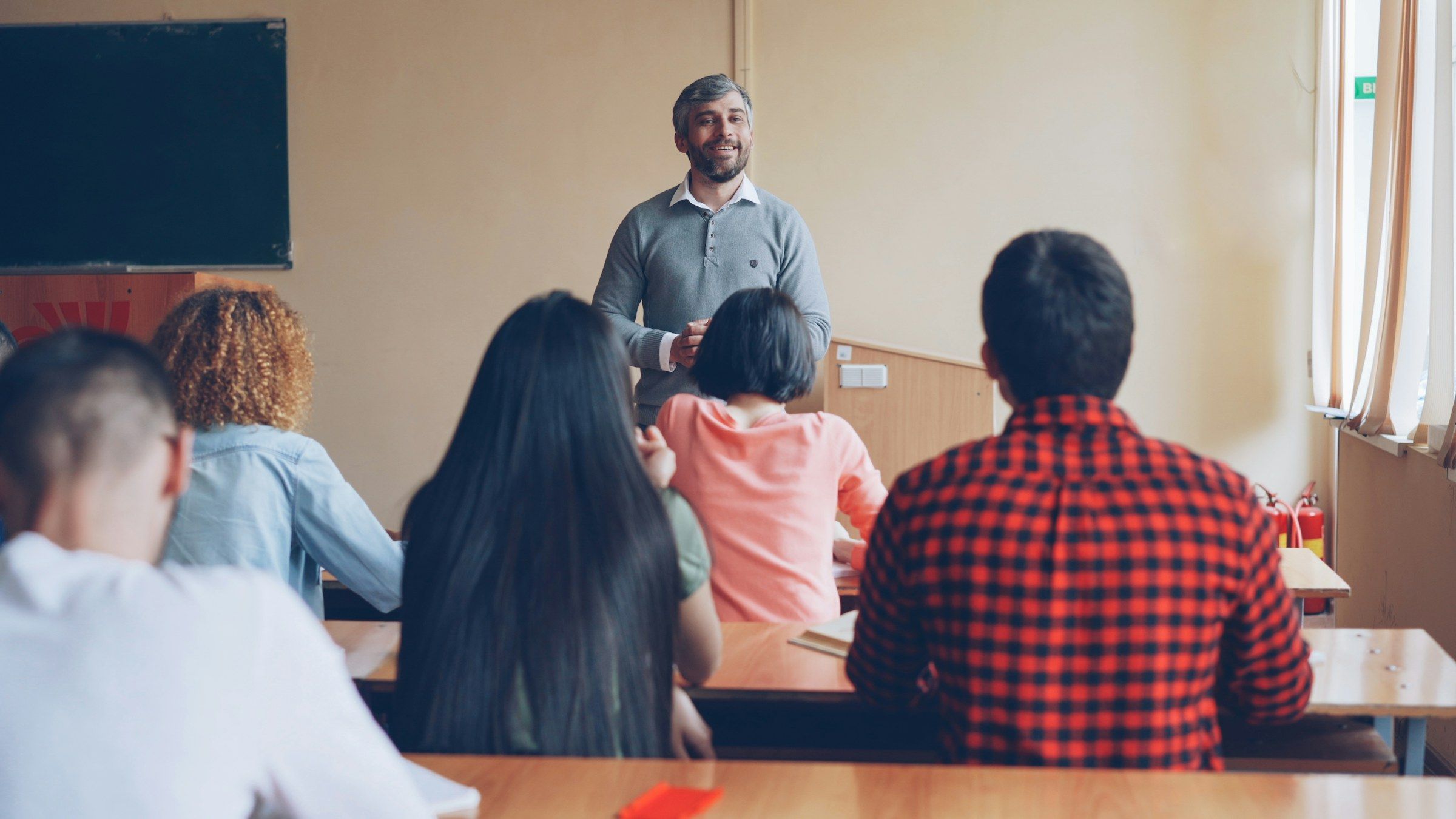 A teacher answers students’ questions in a classroom.